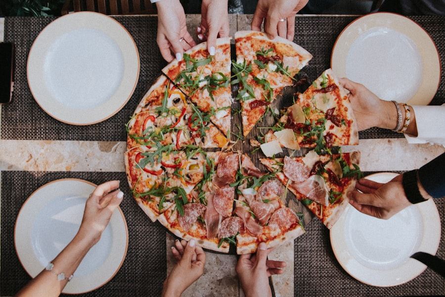 Pizza artesanal servida en un pizza party de Momentos Catering, vista superior con comensales compartiendo