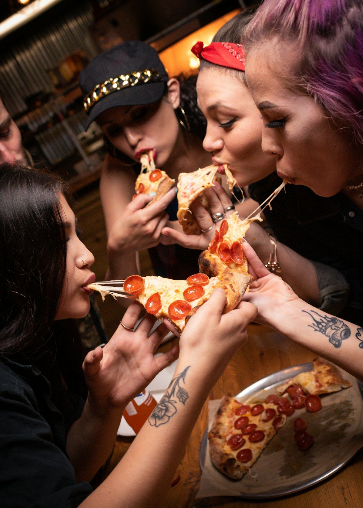 Grupo de amigos compartiendo pizza artesanal en un pizza party organizado por Momentos Catering